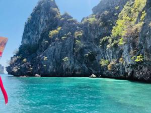 a view of the water in front of a rocky island at เกาะลิบงซันไรส์ โฮมสเตย์ Koh libong sunrise Homestay in Ko Libong