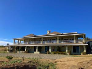 Mi Casa en el Valle de Guadalupe في فالي دي جوادالوبي: منزل أبيض كبير مع شرفة كبيرة