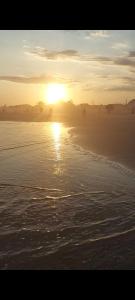 - un coucher de soleil sur la plage dans l'établissement Apto com Varandas 103 - Balneário Arroio do Silva - 3 minutos do Mar, à Arroio do Silva