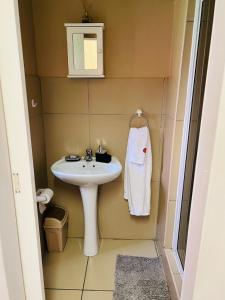 a small bathroom with a sink and a mirror at Lighthouse Inn in Bloemfontein