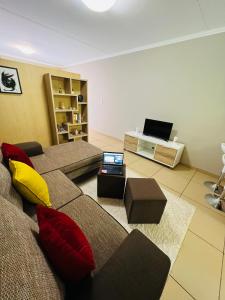 a living room with a couch with a laptop on it at Lighthouse Inn in Bloemfontein +18 photos