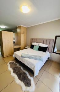 a bedroom with a large bed with furry pillows at Lighthouse Inn in Bloemfontein