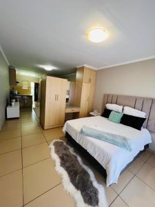 a bedroom with a large bed with a furry rug at Lighthouse Inn in Bloemfontein