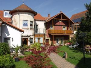 une grande maison avec une tourelle sur une cour dans l'établissement Gutshof Ziegelhütte, à Edenkoben