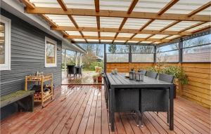 een patio met een houten terras met een pergola bij Pet Friendly Home In Otterup With Wifi in Otterup