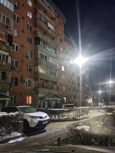 un coche aparcado delante de un edificio por la noche en X.ata 3 en Almaty