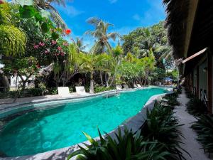 een zwembad in een resort met palmbomen bij Manta Dive Gili Trawangan Resort in Gili Trawangan
