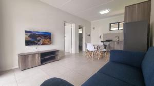 a living room with a blue couch and a table at The Aura in Roodepoort