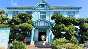 uma casa azul com árvores em frente em Le Port Awashima em Mitoyo
