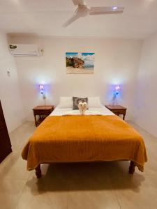 a bedroom with a large bed with two lamps at Anse Grosse Roche Beach Villa in La Digue