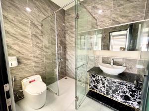 La salle de bains est pourvue de toilettes, d'un lavabo et d'une douche. dans l'établissement QV Manor Hotel, à Phan Rang