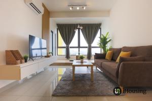 a living room with a couch and a tv at Bali Residence Malacca Premium By I Housing in Melaka