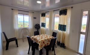 ein Esszimmer mit einem Tisch, Stühlen und Fenstern in der Unterkunft Posada McBean in Providencia