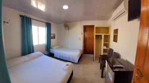 ein kleines Zimmer mit 2 Betten und einem Fenster in der Unterkunft Posada McBean in Providencia