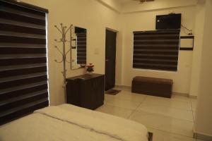 a bedroom with a bed and a window and a television at Anemoi Chimes Resort Calvarymount in Idukki