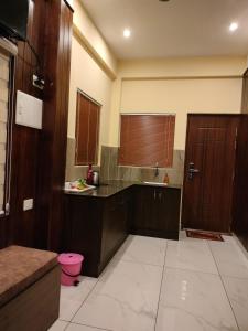 a large kitchen with wooden cabinets and a sink at Anemoi Chimes Resort Calvarymount in Idukki