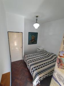 1 dormitorio con 1 cama y una foto en la pared en Casa de papel en Mendoza