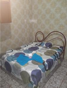 a bed with a blue and white blanket on it at Quarto Casal Térreo perto Pelourinho in Salvador