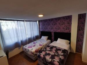 1 dormitorio con 2 camas y ventana en Habitación doble Independiente frente al parque la Carolina, en Quito