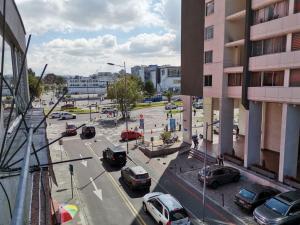 una calle de la ciudad con coches aparcados en un estacionamiento en Habitación doble Independiente frente al parque la Carolina, en Quito