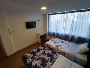 een kleine slaapkamer met een bed en een raam bij Habitación doble Independiente frente al parque la Carolina in Quito