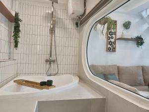 a bathroom with a tub and a round mirror at Mưa home in Da Nang