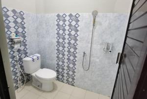 a bathroom with a shower and a toilet in it at Ndalem Kinasih Homestay Syariah in Solo