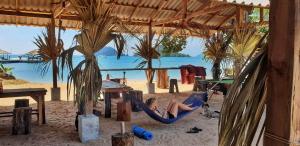 a woman laying in a hammock on a beach at Miss You Beach Resort Koh Mak in Ko Mak