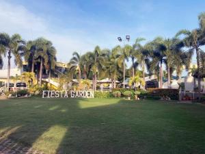un parque con palmeras y un cartel que lee la cámara de fiesta en Fiesta Garden Hotel by SMS Hospitality, en Vigan