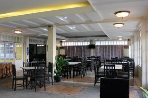 a dining room with tables and chairs and windows at Fiesta Garden Hotel by SMS Hospitality in Vigan