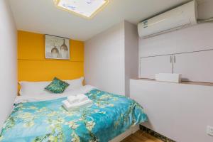 een slaapkamer met een bed met een blauw en geel hoofdeinde bij Lavendar Duplex Apartment in Guangzhou