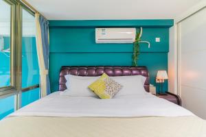 a bedroom with a bed with a blue wall at Lavendar Duplex Apartment in Guangzhou