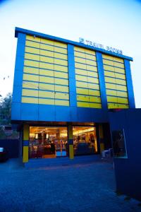 a store front of a building with yellow and blue at Thekkady Travel Rooms in Thekkady