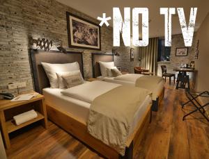 a hotel room with two beds and a no tv sign at LOFT Hotel Bratislava in Bratislava