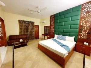 a bedroom with a bed with a green wall at Hotel Imperial Karachi in Karachi