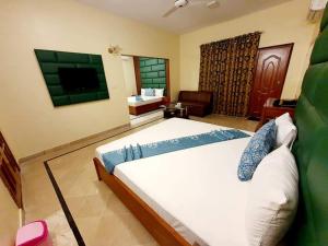 a bedroom with a large bed and a television at Hotel Imperial Karachi in Karachi