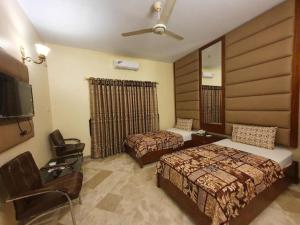 a hotel room with two beds and a flat screen tv at Hotel Imperial Karachi in Karachi