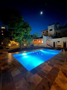 a swimming pool at night with the moon in the background at Bristol Cottages Kilimanjaro in Moshi