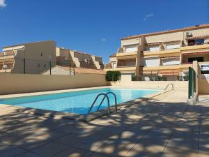 une piscine en face d'un bâtiment dans l'établissement Appartement Marseillan-Plage, 2 pièces, 6 personnes - FR-1-326-643, à Marseillan