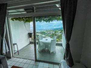 Habitación con vistas a un balcón con mesa y sillas. en MANUNU LODGE 2 days minim, en Faaa