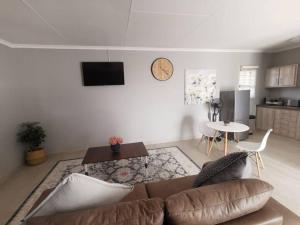 a living room with a couch and a table at HadedaOpiHoek in Postmasburg