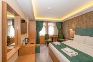 イスタンブールにあるHotel Devmanのベッドとデスクが備わるホテルルームです。