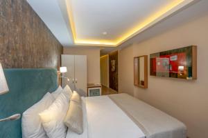 ein Schlafzimmer mit einem großen Bett mit weißen Kissen in der Unterkunft Hotel Devman in Istanbul