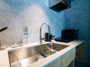 a kitchen with a sink and a microwave at FOX&CRANE Cabin -TSURUI Sauna&Cabins- 