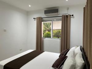 a bedroom with a bed and a window at Paul's Residence in Mahe