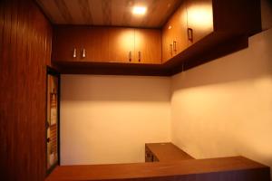 a kitchen with wooden cabinets and a counter top at Thekkady Travel Rooms in Thekkady