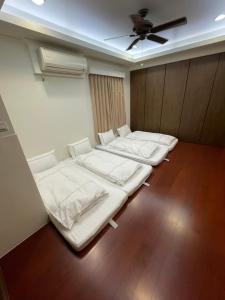 eine Reihe von Betten in einem Zimmer mit einer Decke in der Unterkunft Fun Hotspring in Jiaoxi