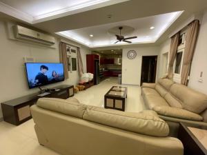 ein Wohnzimmer mit 2 Sofas und einem Flachbild-TV in der Unterkunft Fun Hotspring in Jiaoxi