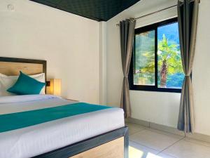 a bedroom with a bed and a window at Euphoric River Resort in Rishīkesh