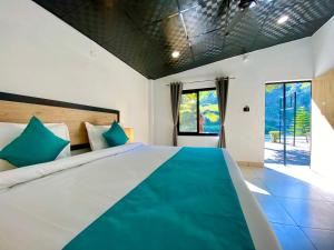 a bedroom with a large bed with blue pillows at Euphoric River Resort in Rishīkesh